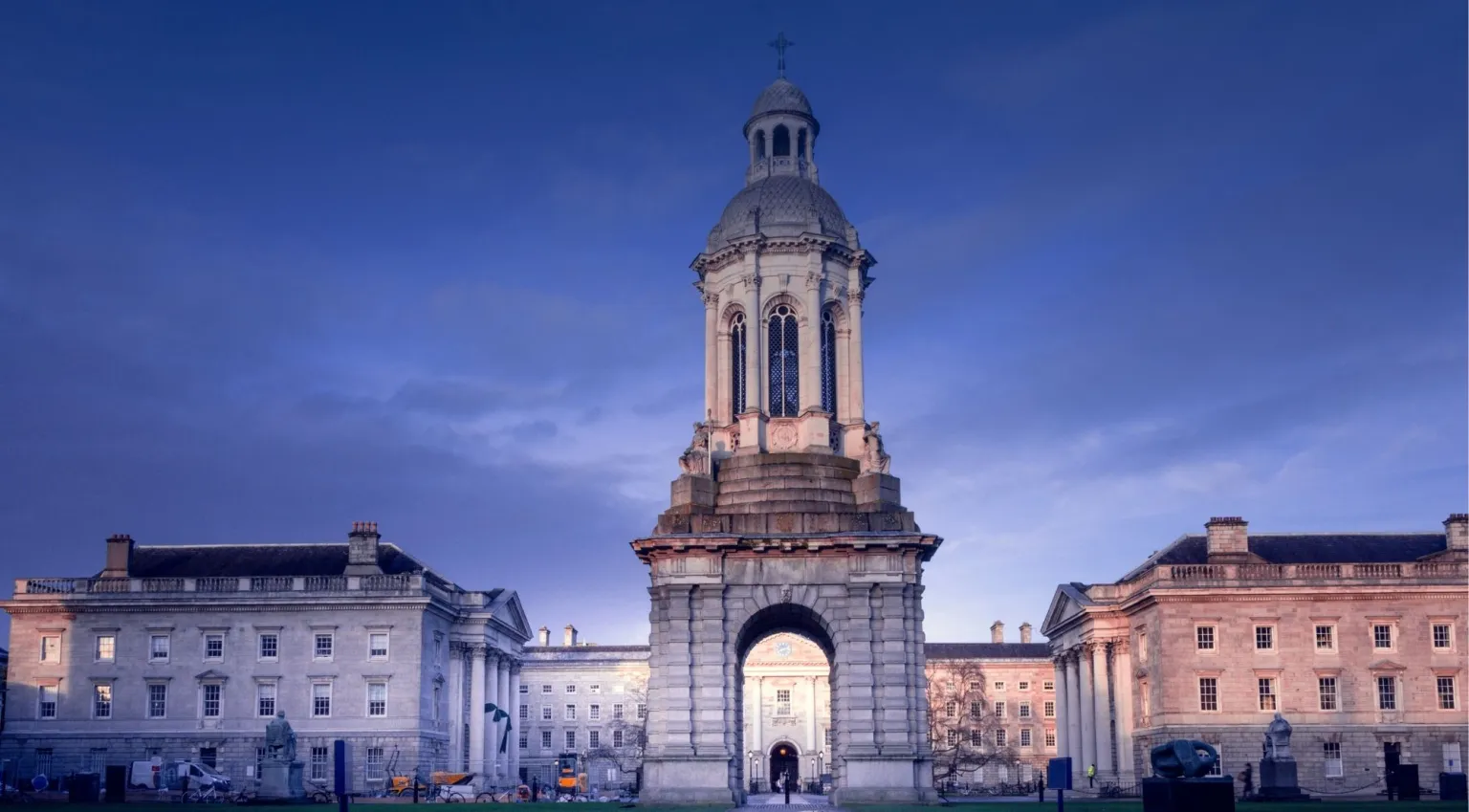 Trinity College Dublin Campanile at dusk — the iconic bell tower lit against a deep blue evening sky